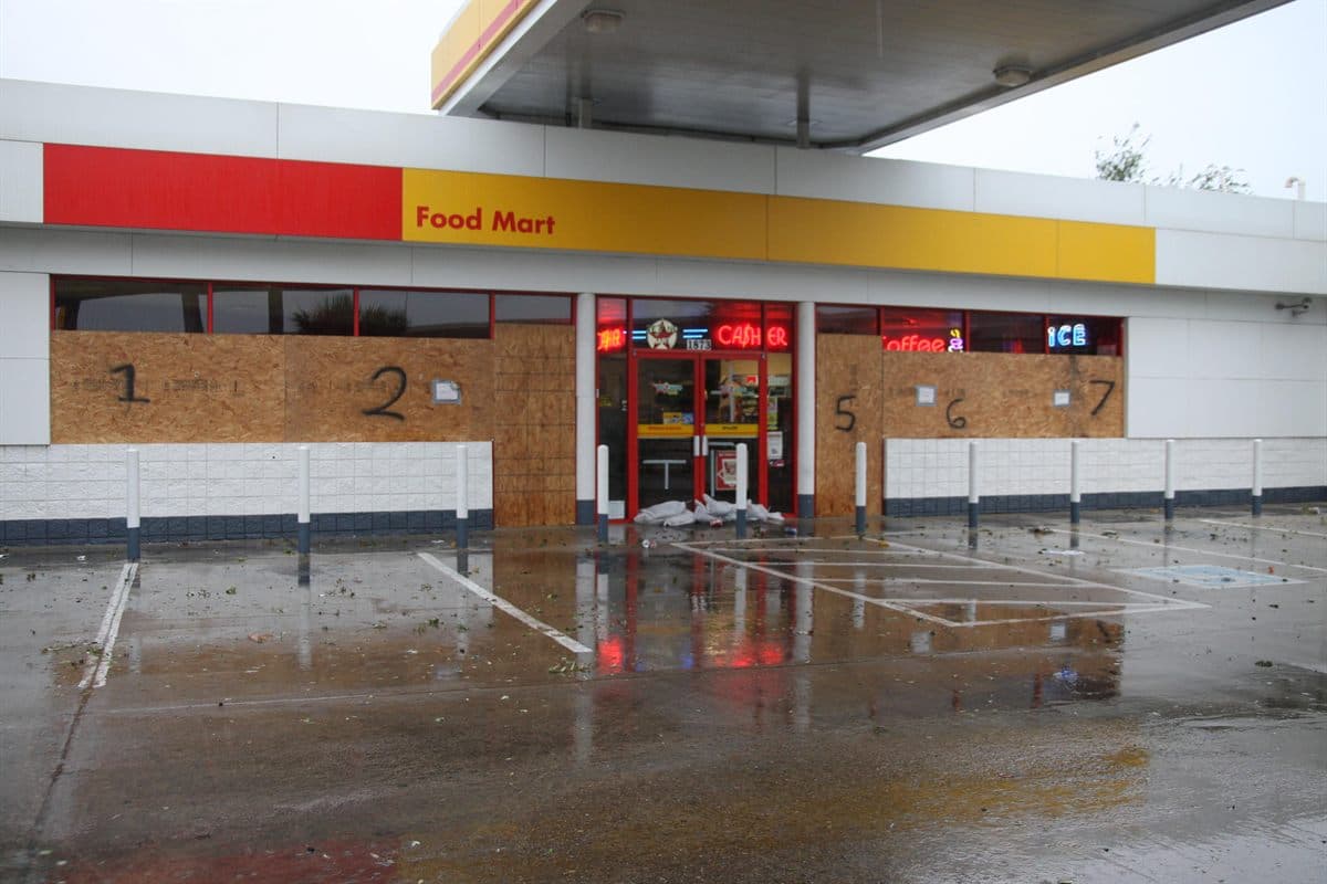Boarded storefront during a hurricane watch vs warning preparation window